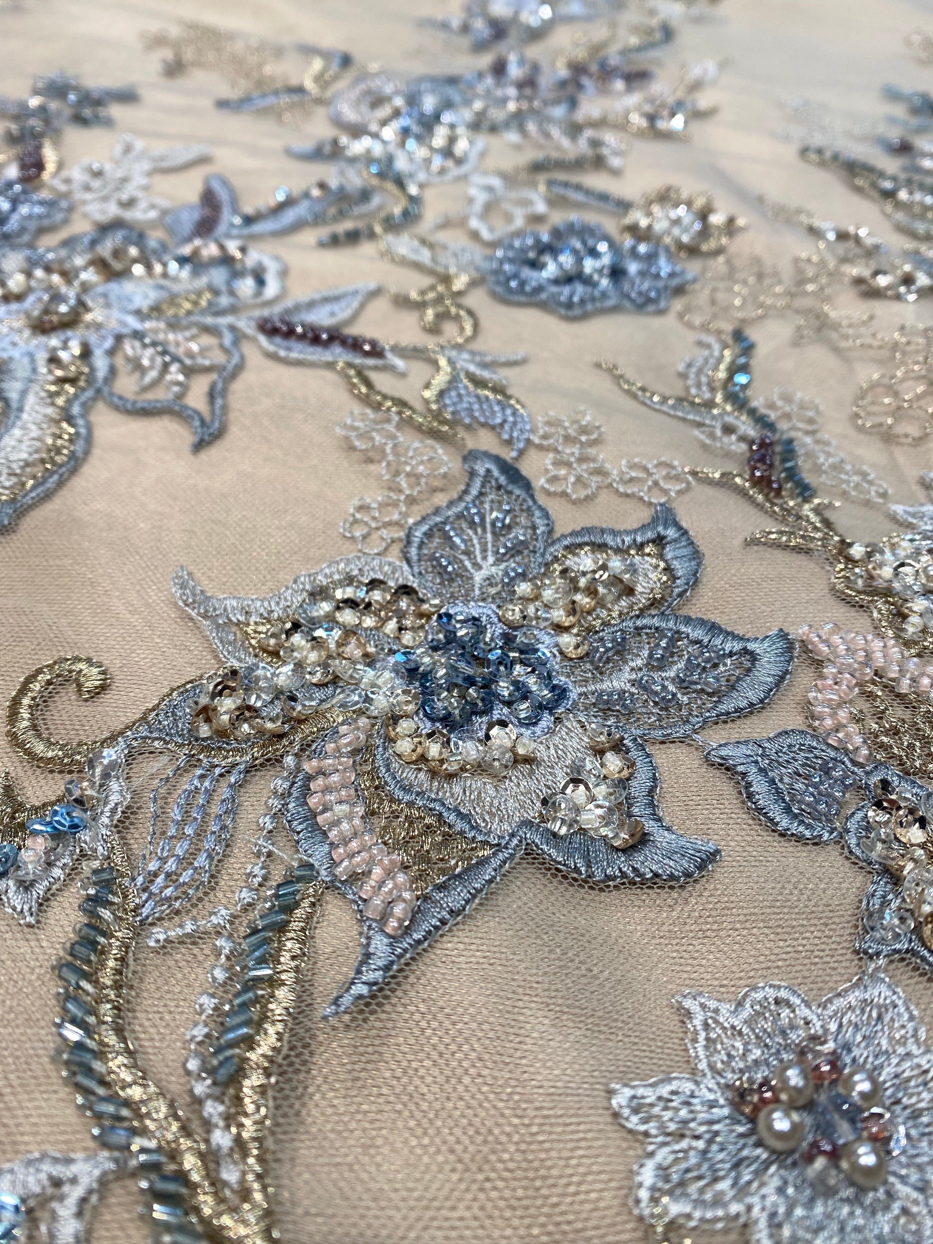 Detailfoto van donker beige kant stof met geborduurde bloemen, zichtbaar patroon en textuur, ideaal voor avondjurk en traditionele kleding